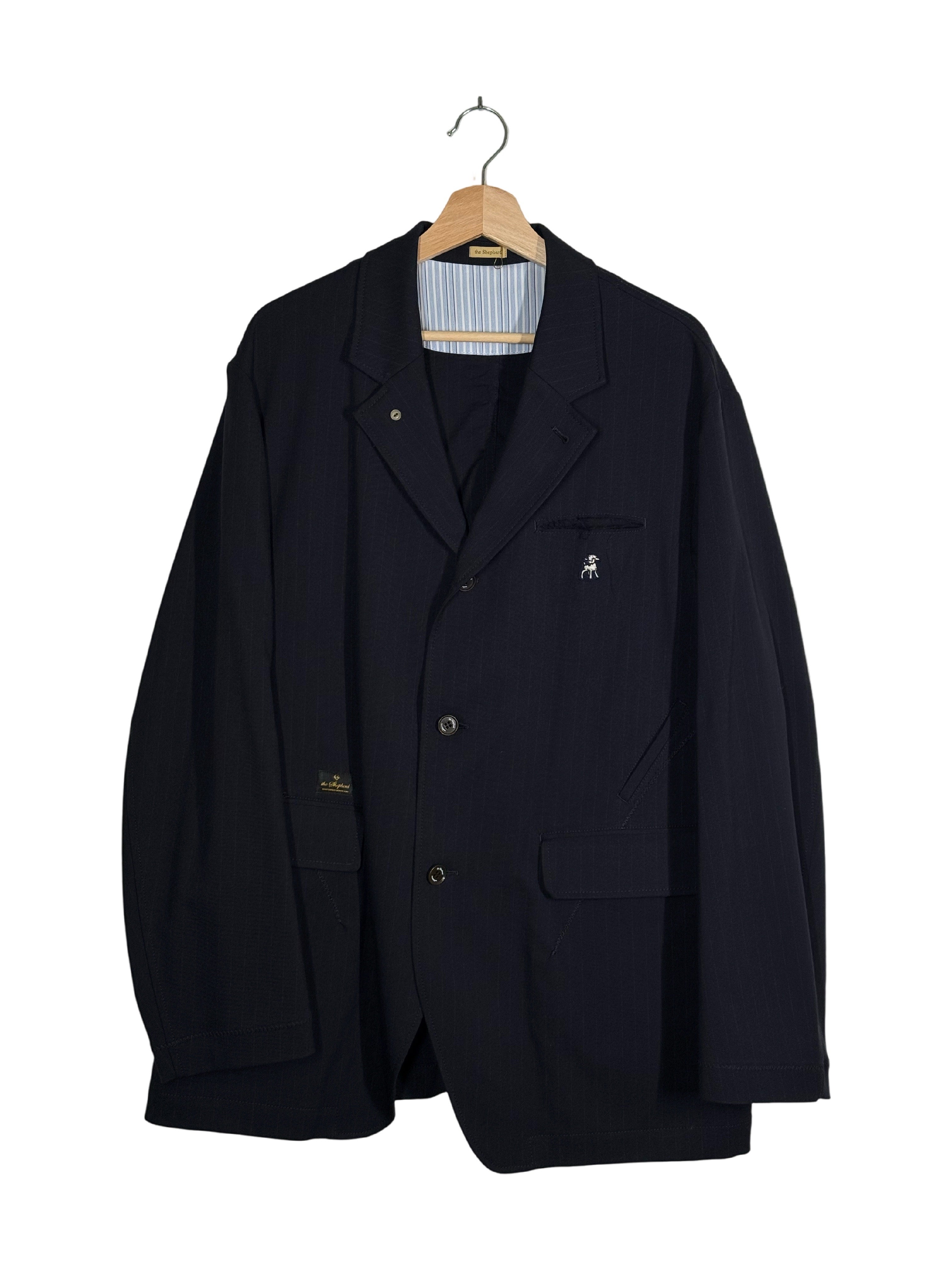Undercover the Shepard 2025SS striped distressed blazer - front view on hanger, raw-cut chest welt pocket with embroidery and tonal zigzag topstitching